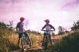 two man riding mountain bike on dirt road at daytime