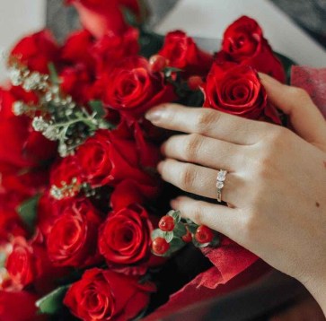 person holding bouquet of red roses